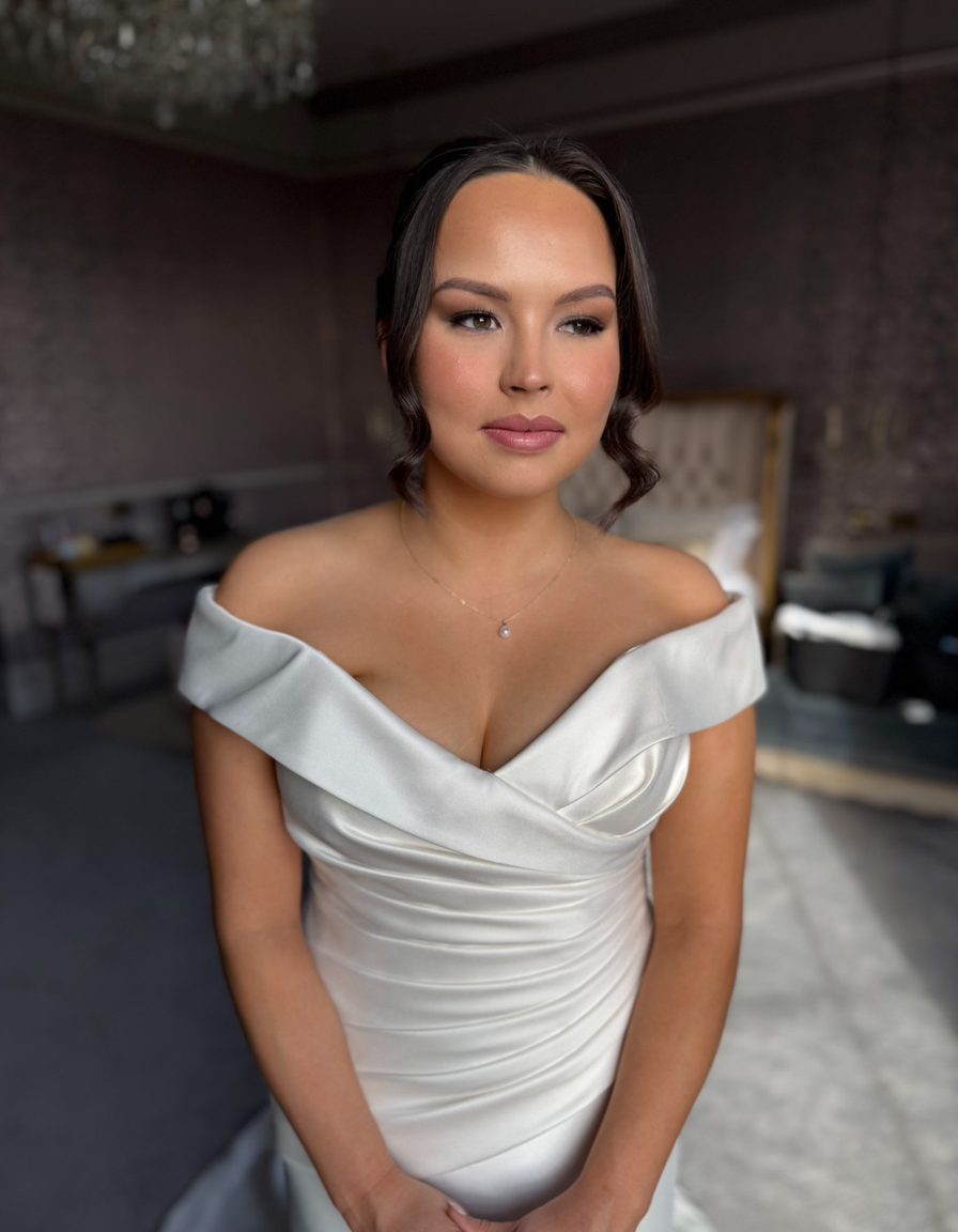 A bride in an off-the-shoulder dress with soft glam makeup